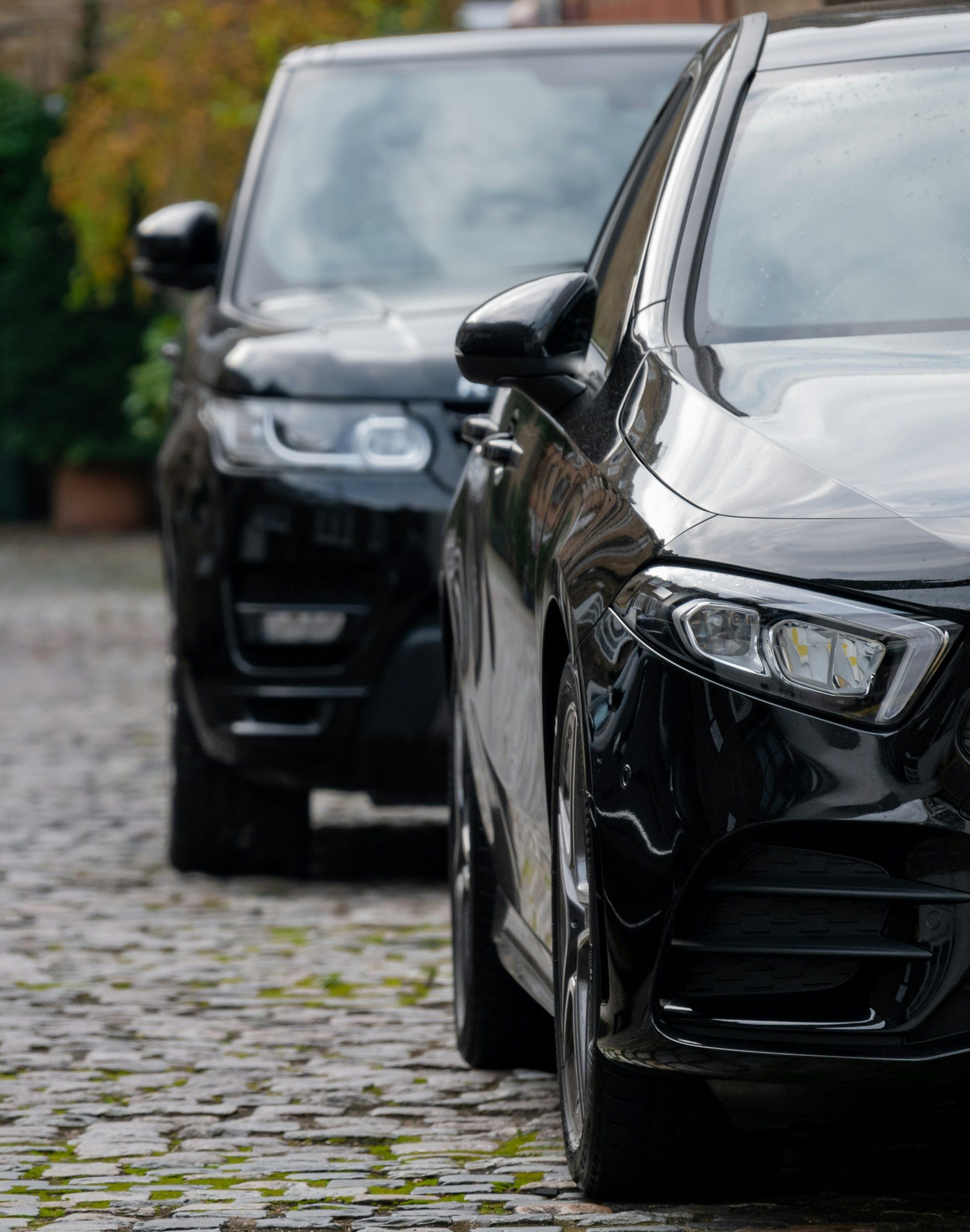 Schwarzer Mercedes-Benz der C-Klasse, der tagsüber auf einem grauen Gehweg geparkt ist.